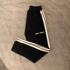 Palm Angels byxor  - Snygga svarta byxor från Palm Angels, är i bra skick, på vissa ställen finns de spår av användning men inget farligt alls, vid behov av fler bilder och övriga information så får ni gärna kontakta mig:) 