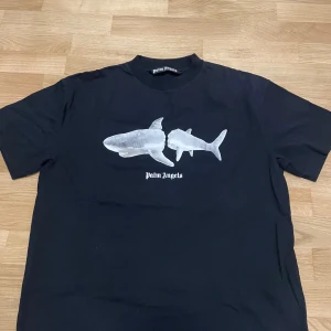 Palm Angels Shark T-Shirt  - Säljer min nya Palm Angels Shark T-shirt som är helt ny med tags fortfarande på som är köpt från Nk och är i storlek L