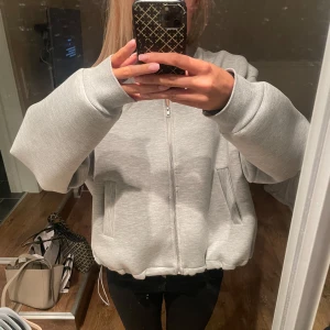 Grå jacka från Gina Tricot - Säljer en grå jacka från Gina Tricot i storlek L. Den har en dragkedja framtill och långa ärmar. 💕