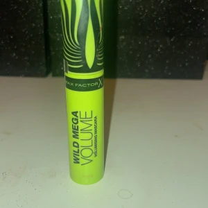 Max Factor Wild Mega Volume Mascara - Säljer en Max Factor Wild Mega Volume Mascara i en iögonfallande limegrön tub med svart mönster. Mascaran har en volymgivande borste som ger fylliga fransar. Perfekt för att skapa en dramatisk look.