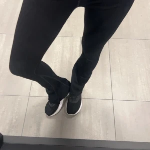 Svarta ribbade byxor - Snygga svarta ribbade byxor med bootcut-stil. Perfekta för en avslappnad look med sneakers eller klä upp med klackar. Bekväma och stilrena för alla tillfällen. Perfekta att ha när du tränar 