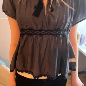 Odd Molly blus  - Unik Odd Molly blus grå/svart. Storlek: S. Är i bra skick förutom att en ”tuss” på ena bandet är borta, det märks dock ej när den är knyten. Pris kan såklart diskuteras!😊