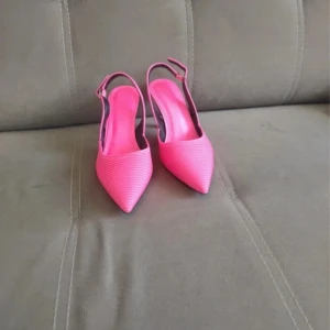 Rosa klackskor med spetsig tå - Snygga rosa klackskor med spetsig tå och slingback-design. Perfekta för att lägga till en färgklick till din outfit.