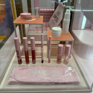 Sminkset från Kylie Cosmetics och Kylie Skin - Ett sminkset med flera produkter från Kylie Cosmetics och Kylie Skin. Innehåller läppstift och läppglans i olika nyanser, en ansiktsmist och en ansiktskräm. Setet inkluderar även en rosa hårband med logotypen 'KYLIE SKIN'. Perfekt för en komplett sminkrutin. På bild nr 2 syns vad som ingår. Köpt i London.
