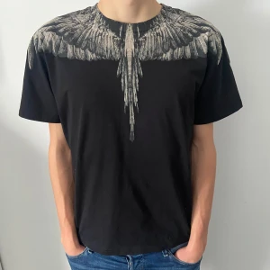 Marcelo Burlon T-shirt  - En riktigt fet T-shirt från märket Marcelo Burlon. Tröjan är i fint skick och storlek M. Modellen på bilden är 190cm och väger 75kg. Hör av dig vid frågor eller funderingar!