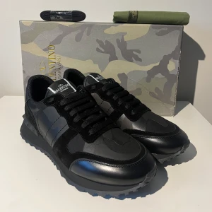 Valentino Rockrunners - Snygga svarta kamouflage rockrunners från Valentino. Oanvända i nyskick 10/10. Fråga gärna efter fler bilder eller info! Priset är inte hugget i sten. Notera även att boxen är sprucken på ena sidan. Skor, dustbag, snörning och box ingår!
