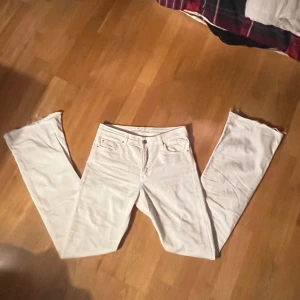 Vita bootcut jeans - Snygga vita bootcut jeans med låg midja. Perfekta för en stilren look. De har klassisk femficksdesign och är tillverkade i ett bekvämt material. Midjemått:34cmx2 innerbenslängden: 82cm