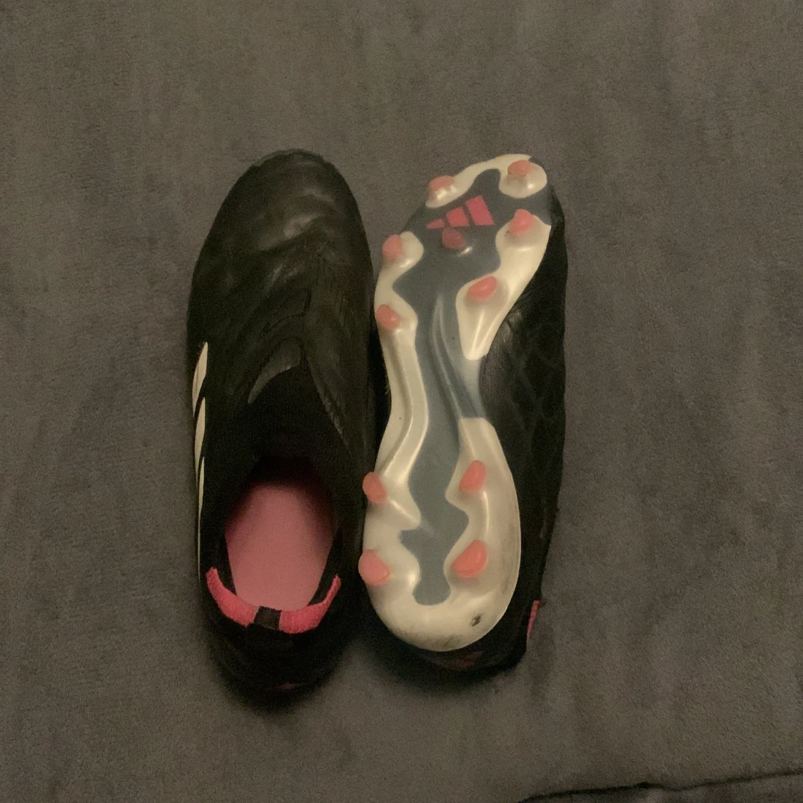 Svarta fotbollsskor med rosa detaljer