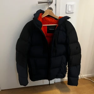 Svart dunjacka från Peak Performance - Säljer en blå orange vinterjacka från peak performance. Jag säljer den då jag har köpt en ny vinterjacka, köpte från johnells
