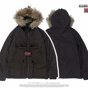 Brun jacka från Napapijri - Säljer en brun jacka från Napapijri med huva och fuskpälsdetaljer. Jackan har dragkedja och ett norskt flaggmärke på framsidan. Den är designad för att tåla kalla väderförhållanden med tejpade sömmar för extra skydd. Chest 45cm. , sleeve length 65cm. , length form shoulder 68cm.