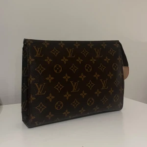 Brun monogramväska - Snygg brun väska. Perfekt för att bära dina nödvändigheter med stil. Väskan har en elegant design och är lätt att matcha med olika outfits.