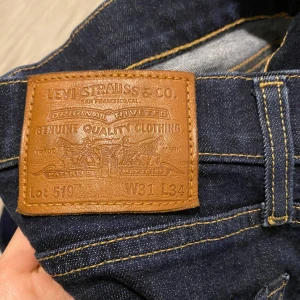 Levi's 510 jeans - Snygga Levi's 510 jeans i mörkblå denim. De har en klassisk femficksdesign och är perfekta för en stilren look. Passformen är tight och de har en knappgylf. Perfekta för både vardag och mer uppklädda tillfällen.