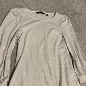 Vit tröja från Vero Moda i storlek xs - Säljer en stilren vit ribbad topp från Vero Moda i storlek xs.💕 Toppen har långa ärmar och en rund halsringning, perfekt för alla säsonger.