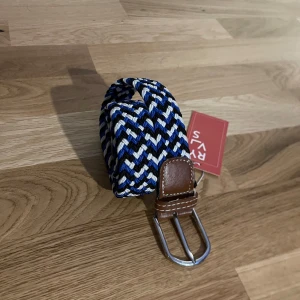 Flätat bälte från RYVLS - Säljer ett snyggt ⚜️ flätat bälte  från RYVLS i blått, svart och vitt. Bältet har en stilren design med bruna skinn-detaljer 🐂 vid spännet. De är i nytt skick och perfekt för att ge din outfit en cool touch! Passar både till vardags och fest. 🖤💙🤍. Nypris 349 kr från kidsbrandstore. Längden är 105 centimeter vilket passar 11-15 år. Kontakta mig vid minsta fundering 🤔 eller prisförslag 🙌🏼