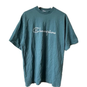 Vintage Champion t-shirt - Säljer en snygg turkos t-shirt från Champion i bra skick. Den har en klassisk passform med korta ärmar och ett stort Champion-tryck på framsidan. Perfekt för vardagsbruk eller träning. Skön och stilren design!