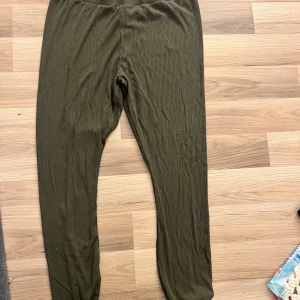 Olivgröna ribbade byxor - Säljer ett par olivgröna ribbade byxor i storlek XL. De är superbekväma och perfekta för en avslappnad dag hemma eller en chill dag ute. Byxorna har en loose fit och är gjorda i ett mjukt material som känns skönt mot huden. Perfekta för höst och vår!