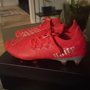 Röda fotbollsskor från New Balance - Bukayo Sakas egna limiterade fotbollsskor. Dessa skor är hyfsat exklusiva då dom inte går att få tag i längre. Jag säljer dom då dom var lite små. Använda ca 40 min.