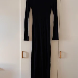 Svart långklänning från Gina Tricot - Snygg svart långklänning från Gina Tricot i storlek XXS. Klänningen har en elegant och enkel design med långa ärmar, perfekt för både vardag och fest. Materialet känns mjukt och bekvämt mot huden. Ett måste i garderoben för en stilren look!