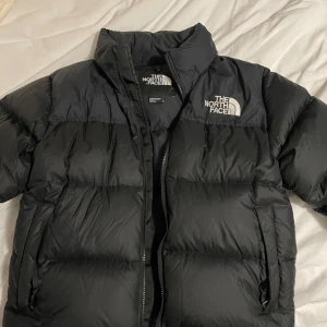 1996 RETRO NUPTSE JACKET - Säljer en svart vinterjacka i dun från The North Face i storlek M. Använd 3 gånger. Släpper inte för mindre än 2000