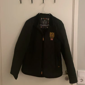 Svart quiltad jacka från Morris - Säljer en snygg svart quiltad jacka från Morris i storlek small. Jackan har ett broderat emblem på bröstet och en dragkedja med läderdetalj. Perfekt nu till vintern. Nypris: 2000kr mitt pris: 600kr