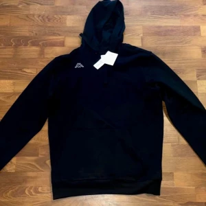 Kappa hoodie Ny - Säljer en svart hoodie från Kappa i storlek XL. Helt ny