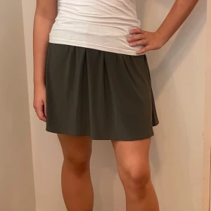 Grön kortkjol - Säljer en superfin grön kortkjol i ett mjukt och flödande material. Perfekt för sommardagar eller en avslappnad vårlook. Kjolen har en elastisk midja för extra komfort och en lös passform som ger en skön känsla. Passar perfekt till en enkel topp eller linne. 🥰