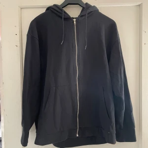 Svart hoodie med dragkedja - Säljer en svart hoodie från 157 i storlek M. Den har en dragkedja framtill och en mysig huva. Perfekt för kyliga dagar eller som ett extra lager. Den är i bra skick och passar till det mesta i garderoben. Skön och enkel stil! 🖤
