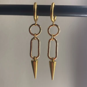 Guldiga örhängen - Det är ett par guldiga örhängen