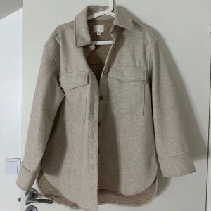 Beige kappa - Beige kappa i nytt skick, storlek XS på kappan men den passar även S och M då den är oversize. Köpt från HM, nypris 499kr. Bara använd någon enstaka gång.