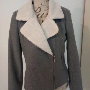 Ny söt grå jacka stl M - Snygg grå jacka med vit pälskrage. Jackan har en dragkedja framtill och två fickor på sidorna. Jackan är väldigt fin,  fordrad Kommer från djur och rökfritt hem