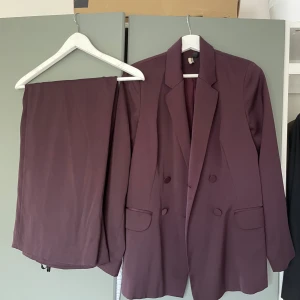 Vinröd/lila kostym från Topshop  - Super fin kostym från Topshop. Mycket sparsamt använd men tyvärr har byxorna fått sig lite stryk av en handsydd uppläggning. Kavajen är som ny🌟   Finns att hämta i Uppsala, alternativt skickas mot fraktkostnad! 