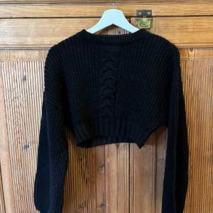 Stickad tröja  - Croppad stickad tröja i svart från NA-KD. Storlek xxs. Använd några gånger.