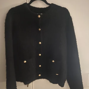 Svart cardigan  - Ganska liten i storleken, den är inte nopprig utan materialet ser ut som på bild två