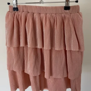 Rosa glittrig kjol - Fin rosa kjol i gott skick från NAKD, lapp finns ej kvar men storlek passar nån i S/M!!