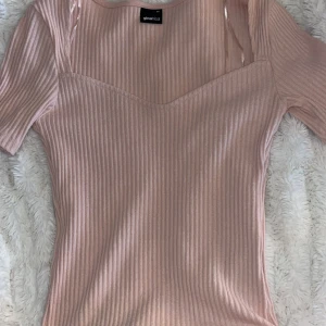 Rosa topp - Säljer en söt ljus rosa topp med v-ring. Tröjan kommer inte till användning så jag har valt att sälja den. Använd två gånger 💗