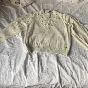 Fin vit stickad kofta med bollar på - Jag säljer denna kofta pga jag aldrig använder den och jag tycker inte om den lika mycket som förr, den är knappast använd och kommer i god skick💗