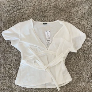 Vit v-ringad knyt topp - Vit knyt topp från Gina i storlek m men passar s, aldrig använd. Jämnt slutsåld
