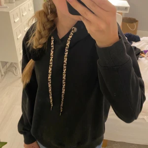 Hoodie - Säljer en svart hoodie med leopardmönstrade snören. jag böt ut snörena själv så de är inte helt perfekt sytt men ändå bra. hoodien är dock ganska urtvättad men den är fortfarande såå snygg