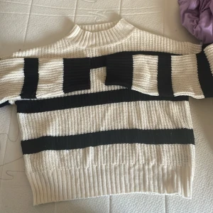 Randig stickad tröja - Säljer en supermysig stickad tröja med breda svarta och vita ränder. Den är perfekt för kyliga dagar. Tröjan är i bra skick och passar perfekt till både jeans och kjol. Perfekt för höst och vinter!
