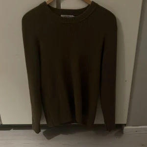 Olivgrön stickad tröja från Ljung by Marcus Larsson - Säljer en snygg Brun stickad tröja från Ljung by Marcus Larsson. Den har en ribbad struktur och är perfekt för höst och vinter. Tröjan är långärmad och i storlek S. Perfekt för en stilren och bekväm look! Ny priss 1500 Aldrig använd!