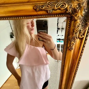 Ljusrosa off-shoulder topp - Säljer en superfin ljusrosa off-shoulder topp med volangdetaljer. Köpt secondhand och om du har några fler frågor är det bara att kontakta mig 🌸