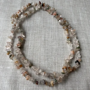 Halsband med stenar i olika färger - Säljer ett unikt halsband med små, oregelbundna stenar i olika naturliga färger som beige, grön, brun och grå. Perfekt för att ge en bohemisk touch till din outfit. Halsbandet är långt och kan bäras både enkelt eller dubbelt för en fylligare look.