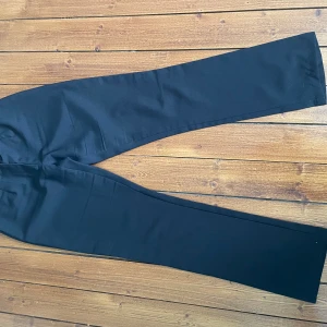 Kostymbyxor  - Svarta kostymbyxor med silver detaljer. Använda men i fint skick. Storlek 38