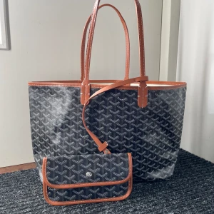 Goyard väska i svart och med bruna detaljer Tote bag   - Helt ny Goyard väska som aldrig är använd utan en present som inte passade mig. Modern och populär modell på väska. Bra storlek för det mesta. Det är även en liten plånbok eller väska som kommer med på köpet. 