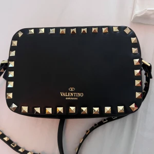 Valentino garavani väska - Säljer denna oerhört snygga valentino garavani rockstud camera bag. Den är i väldigt bra skick och tillkommer med dustbag, låda osv. Den är klassisk och stilren och passar till allt.💕