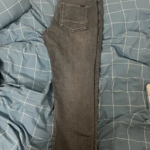 Grå jeans från C&A - Säljer ett par snygga grå jeans från C&A. De har en klassisk femficksdesign och en bekväm passform. Perfekta för både vardag och fest!