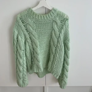 Mintgrön kabelstickad tröja från NAKD - Säljer nu denna populära kabelstickade tröja från NAKD. Använd fåtal gånger, mindre tendenser på smink vid kragen som troligtvis enkelt kan tvättas bort (och som knappt syns)💛