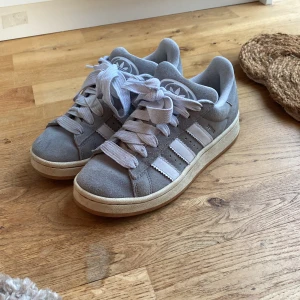 Grå Adidas sneakers i storlek 37 - Säljer ett par snygga gråa Adidas campus i storlek 37 1/3. Skorna kommer i originalkartong. Köptes i våras men användes bara några veckor. Sulan tvättas innan jag skickar de! Super bra skick.❤️Nypris 1200. Pris går att diskutera😍❤️