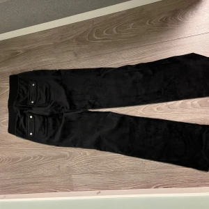 Svarta byxor från Juicy Couture - Säljer ett par svarta byxor från Juicy Couture i storlek XXS. Byxorna har en klassisk design med fickor och är perfekta för en avslappnad stil. De är gjorda i ett mjukt material som känns skönt mot huden.