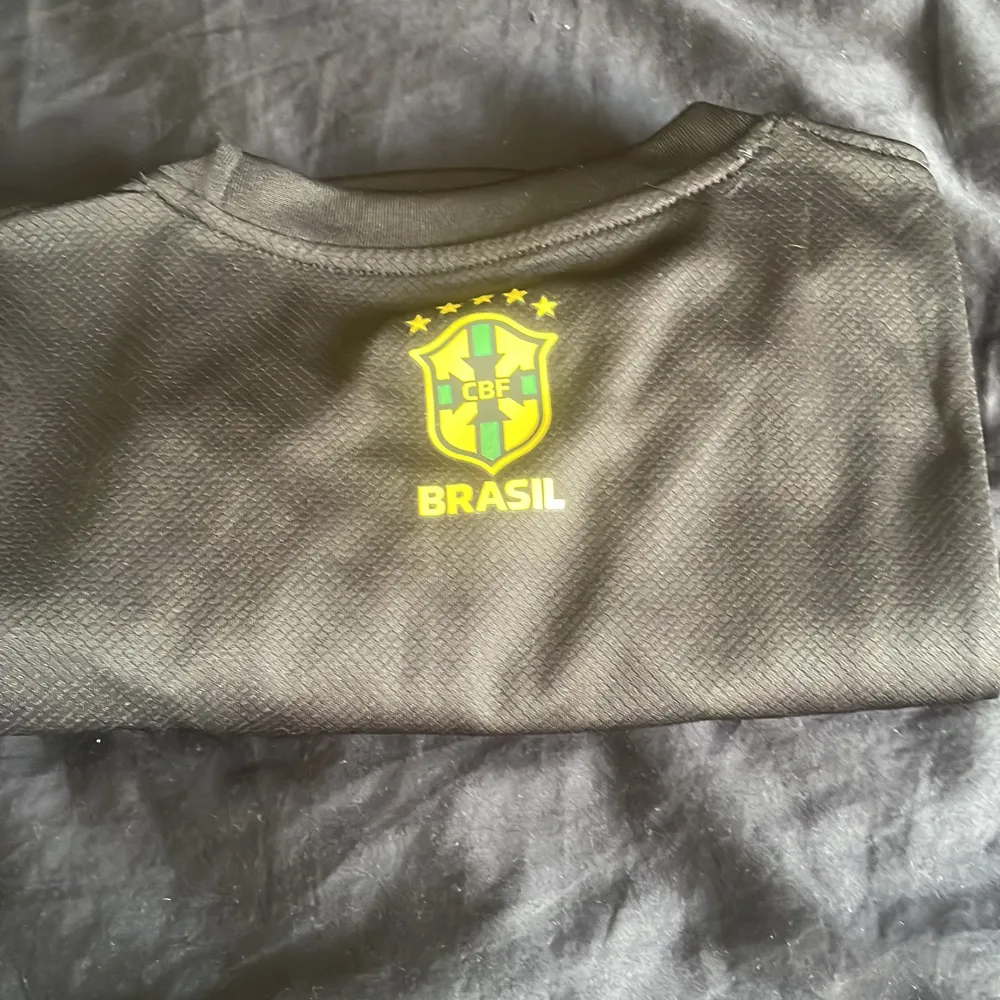 En Brasilien t-shirt i perfekt skick. Använd 1 gång. Kan användas till träning men även i vardagen. Jag säljer denna för endast 199kr då den är lite stor. (Storlek M). Hör gärna av er vid frågor eller om ni önskar fler bilder😃. T-shirts.